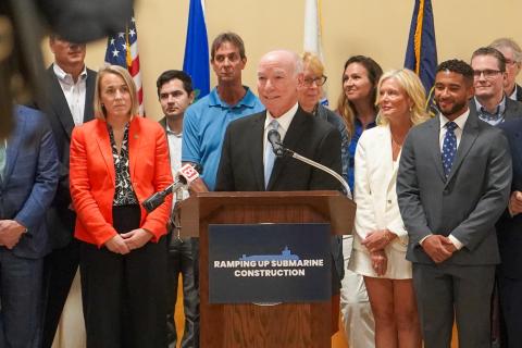 Congressman Joe Courtney smiles while speaking at a press conference.